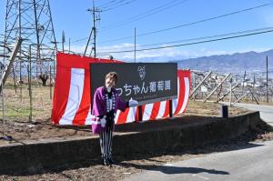 看板の前でほほ笑む小林幸子さん